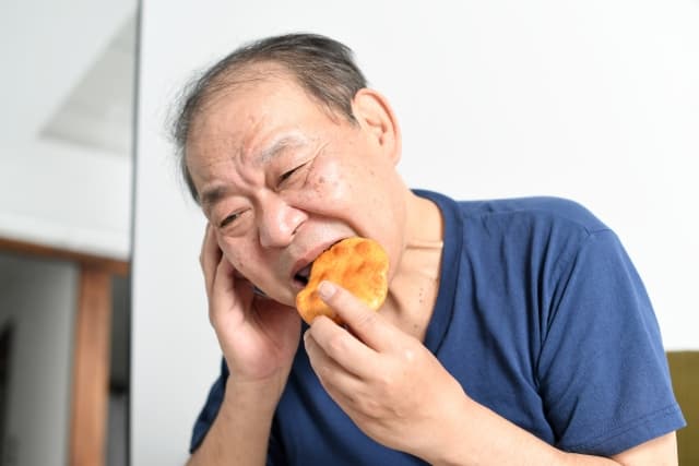 せんべいを食べる高齢男性