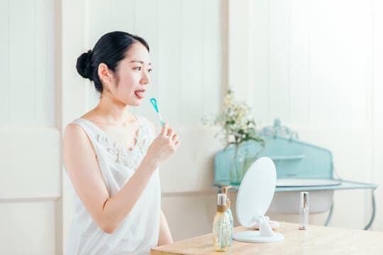 舌ブラシを使用する女性