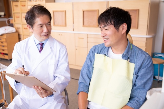歯科医院で差し歯の相談をする男性