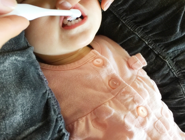 仕上げ磨きをしてもらう子供