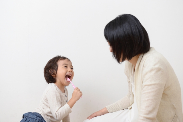 母親の前で歯磨きをする子供