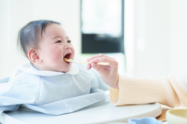 スプーンを赤ちゃんの口へ運ぶ様子