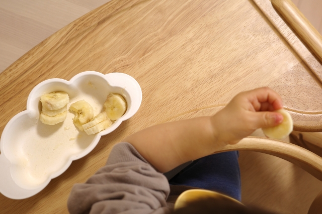 赤ちゃんが手づかみ食べをする様子