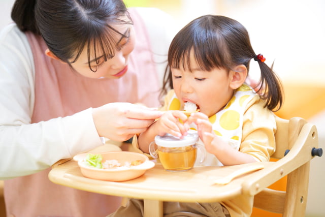 ごはんを食べさせてもらう女の子