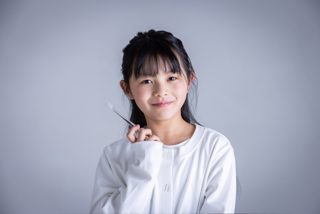 歯ブラシを手に笑顔を見せる女の子