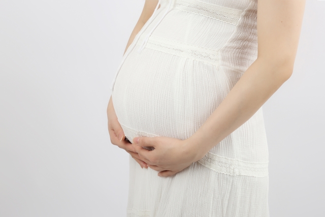 お腹に手をあてる妊娠中の女性